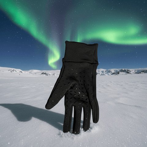 Black glove in the snow with the Northern Lights in the background
