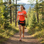 Woman running a forest trail wearing the Gearhead Running Belt