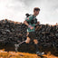 Runner wearing the Adventure Pack 20L beside a stone wall