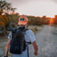 Back view of the black Adventure Pack 20L on a hiker at sunset