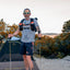Hiker with trekking poles wearing the Adventure Pack 20L at camp